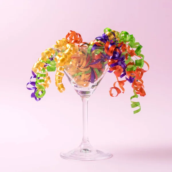 パーティーストリーマーとのマティーニグラスはピンクの背景に。最小限のパーティーのコンセプト. — ストック写真