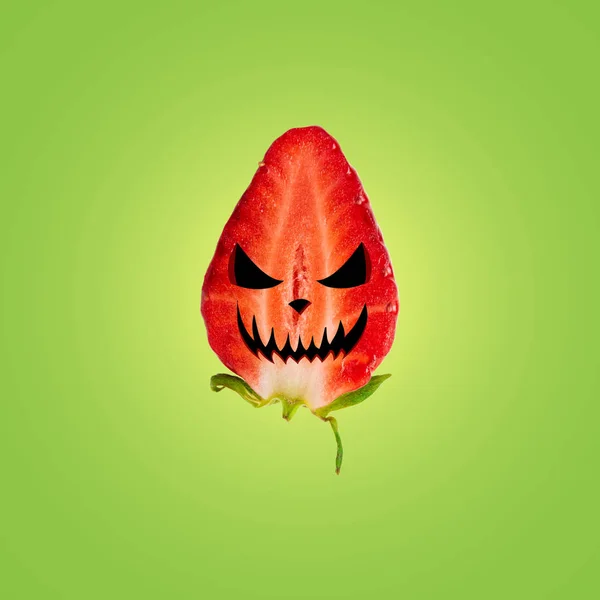 Cara de Halloween em morango maduro em fundo brilhante. Halloween conceito mínimo . — Fotografia de Stock