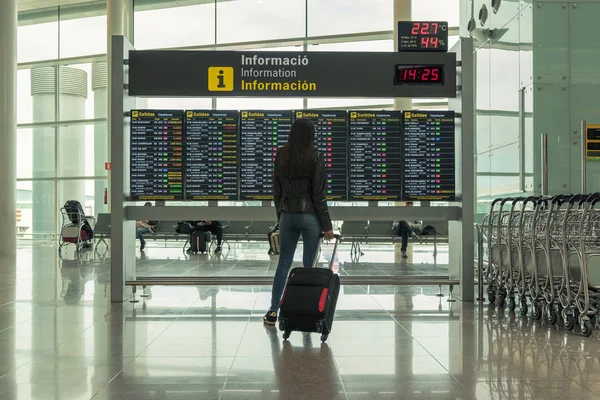 Giovane donna con valigia nella sala partenze dell'aeroporto. Concetto di viaggio . — Foto Stock
