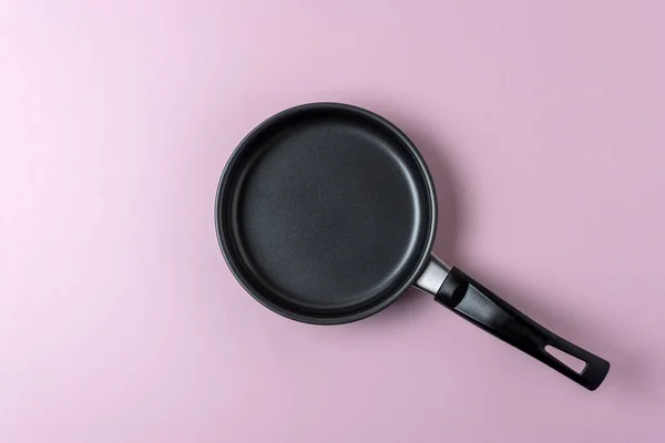 Kleine koekenpan op pastel roze achtergrond. Minimale voedsel concept — Stockfoto