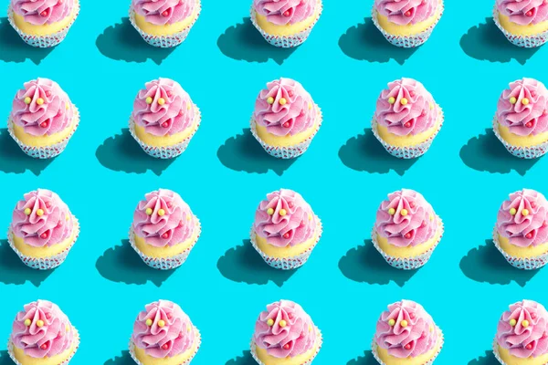 Kleurrijke cupcake patroon op pastel blauwe achtergrond. Creatief minimaal feest concept. — Stockfoto