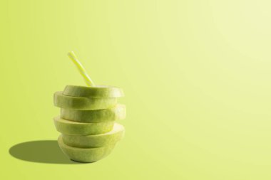 Parlak arka planda dilimlenmiş elma ve saman ile yaratıcı kompozisyon. Minimal meyve konsepti. 