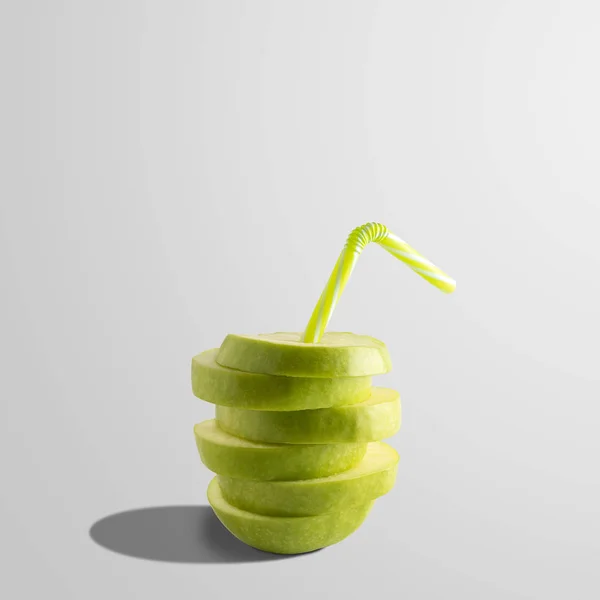 Kreativ komposition med äppeljuice och halm på ljus bakgrund. Minimal frukt koncept. — Stockfoto