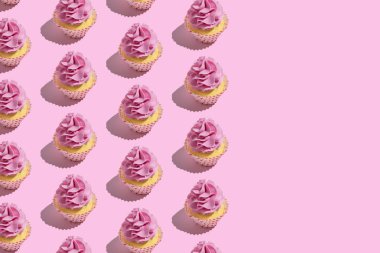 Pastel pembe arka plan üzerinde renkli cupcake desen. Yaratıcı minimal parti konsepti.