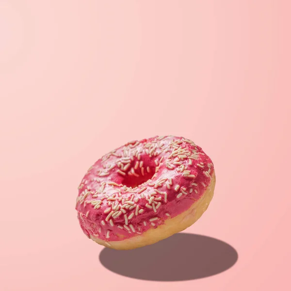 Pastel pembe arka plan üzerine sırlı donut. Yaratıcı minimal kavram — Stok fotoğraf