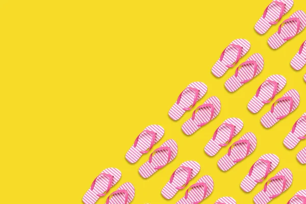 Padrão de chinelos de praia criativo no fundo amarelo. Verão conceito mínimo . — Fotografia de Stock