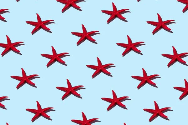 Creative  red starfish pattern on blue background. Summer minimal concept. — Stock Photo, Image