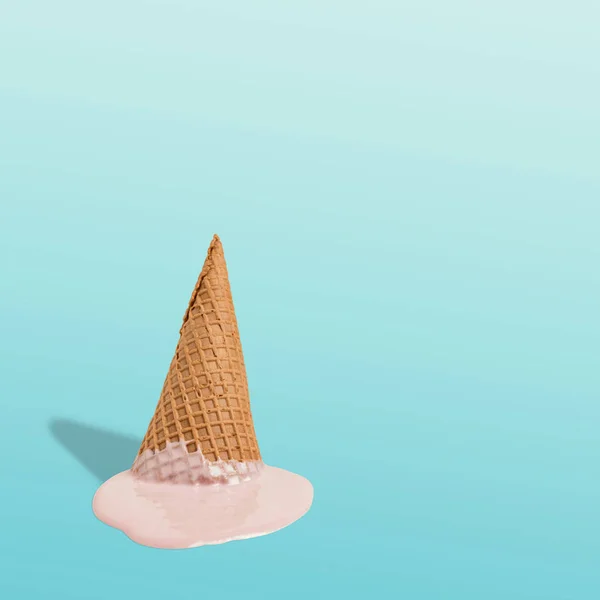 Melted ice cream with ice cream cone on pastel blue background. Minimal summer food concept. — Stock Photo, Image