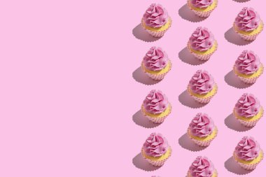 Pastel pembe arka plan üzerinde renkli cupcake desen. Yaratıcı minimal parti konsepti.
