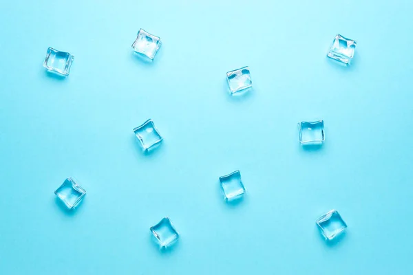 Cubos de hielo sobre fondo azul brillante. Concepto mínimo de bebida de verano. Puesta plana . —  Fotos de Stock