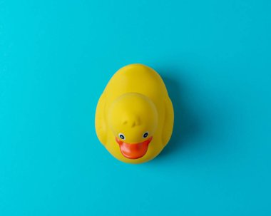 Mavi arka planda sarı plastik ördek. Yaz asgari kavramı.