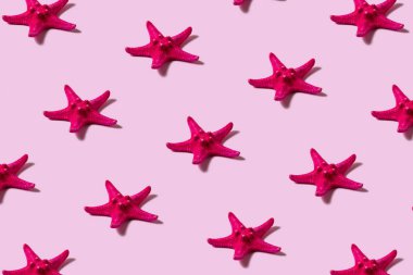 Pembe arka planda yaratıcı kırmızı denizyıldızı deseni. Yaz minimal kavramı.