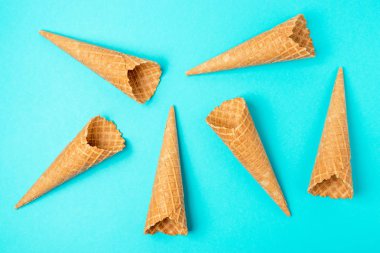 Mavi arka planda çeşitli dondurma konileri. Minimal yaz konsepti.