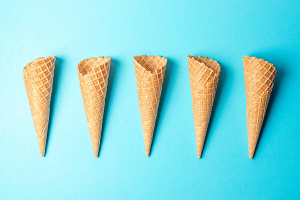 Various ice cream cones on blue background. Minimal summer concept.