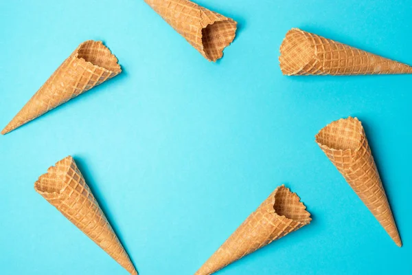 Vários cones de sorvete no fundo azul. Conceito mínimo de verão . — Fotografia de Stock