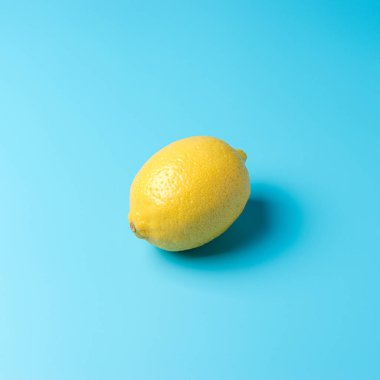 Mavi arka planda taze limon. Minimal gıda konsepti.