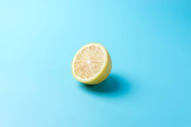 Mavi arka planda taze dilimlenmiş limon. En az gıda konsepti.