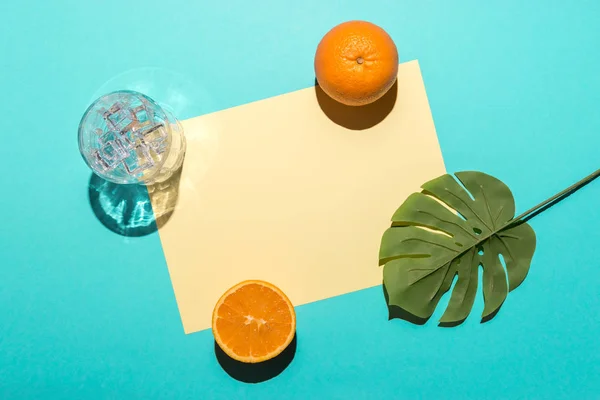 Tropical palm leaf with sliced orange on bright blue background. Minimal summer composition. Flat lay. — Stock Photo, Image