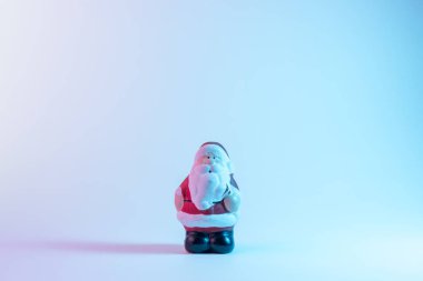 Canlı, çarpıcı, gradyan holografik renklerde küçük bir Noel Baba. Noel ve Yeni Yıl minimum sanat konsepti.