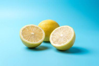 Mavi arka planda taze dilimlenmiş limon. En az gıda konsepti.