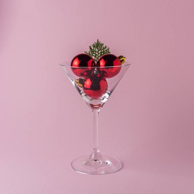 Pastel pembe arka planda martini cam Noel ağacı bauble.