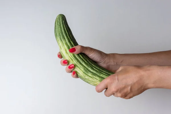 Women hand holding cucumber like a man's penis on white background. — Stock Photo, Image