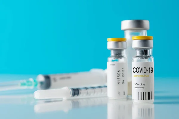 Skleněná Lahvička Vakcínou Proti Koronaviru Injekční Stříkačkou Modrém Pozadí Koncepce — Stock fotografie