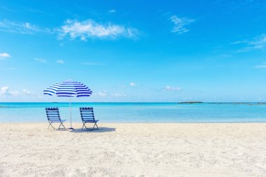 Tropik plajda şemsiyenin altında iki sandalye. Yaz tatili kavramı.