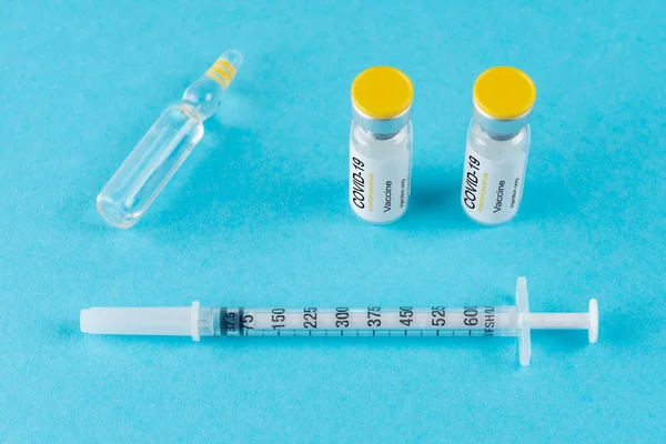 Glazen Injectieflacon Met Coronavirus Vaccin Met Een Spuit Blauwe Achtergrond — Stockfoto