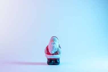 Canlı, çarpıcı, gradyan holografik renklerde küçük bir Noel Baba. Noel ve Yeni Yıl minimum sanat konsepti.