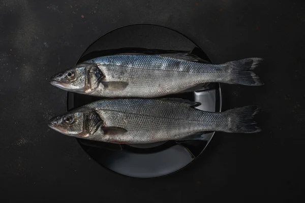 Дві Свіжі Морські Риби Чорній Тарілці Концепція Морепродуктів — стокове фото