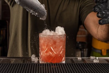Bardaki barmen buzlu alkollü kokteyl yapıyor. Yaz partisi geçmişi.