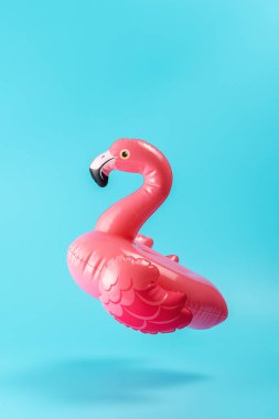 Mavi arka planda şişme havuz oyuncağı flamingosu. Asgari yaz konsepti.