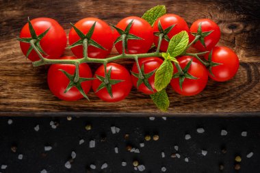 Ahşap arka planda baharatlı taze kiraz domatesleri. Yemek arkaplanı. Üst görünüm.