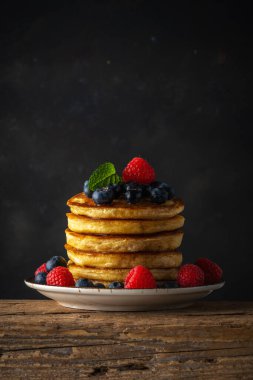Köy ahşap masasında taze böğürtlenli leziz krepler. Yiyecek konsepti.