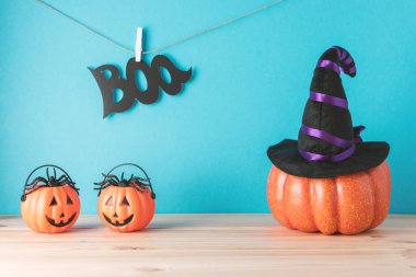 Cadılar Bayramı balkabağı dekoru ve tahta masanın üstünde cadı şapkası olan tatil konsepti. Yaratıcı Cadılar Bayramı minimum konsepti.