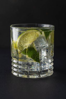 Bardakta köpüklü suyla limon dilimi. Yaz içeceği kavramı.