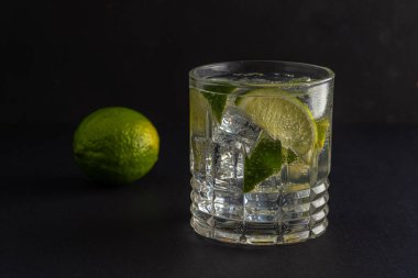 Bardakta köpüklü suyla limon dilimi. Yaz içeceği kavramı.