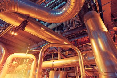 Modern bir endüstriyel santralde bulunan ekipman, kablolar ve borular. Sanayi bölgesi, çelik boru hatları, vanalar, kablolar ve yürüyüş yolu.