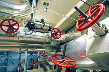 Modern bir endüstriyel santralde bulunan ekipman, kablolar ve borular. Sanayi bölgesi, çelik boru hatları, vanalar, kablolar ve yürüyüş yolu.