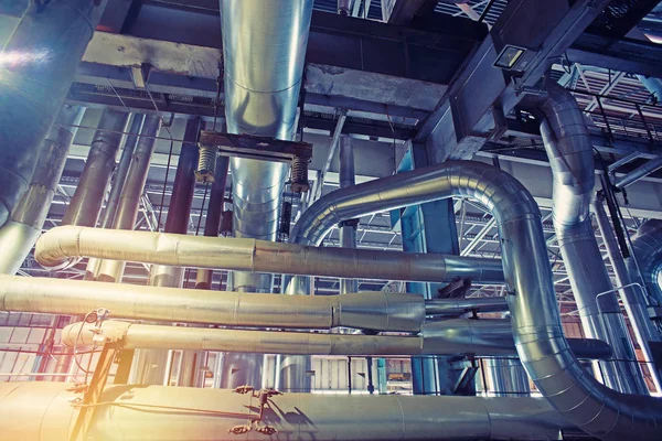 Modern bir endüstriyel santralde bulunan ekipman, kablolar ve borular. Sanayi bölgesi, çelik boru hatları, vanalar, kablolar ve yürüyüş yolu.