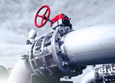 Endüstriyel bölge, çelik boru hatları ve vanalar mavi gökyüzüne karşı