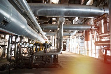 Modern bir endüstriyel santralde bulunan ekipman, kablolar ve borular. Sanayi bölgesi, çelik boru hatları, vanalar, kablolar ve yürüyüş yolu.