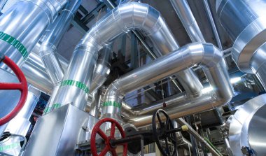 Modern bir endüstriyel santralde bulunan ekipman, kablolar ve borular. Sanayi bölgesi, çelik boru hatları, vanalar, kablolar ve yürüyüş yolu.