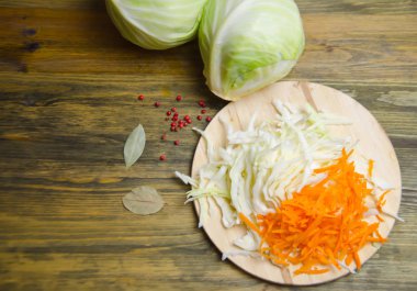 lahana başkanları ve ahşap zemin üzerine dilimlenmiş lahana ve havuç dilimleri 