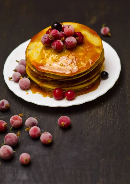 Crêpes avec confiture et baies sur fond noir en bois — Photo