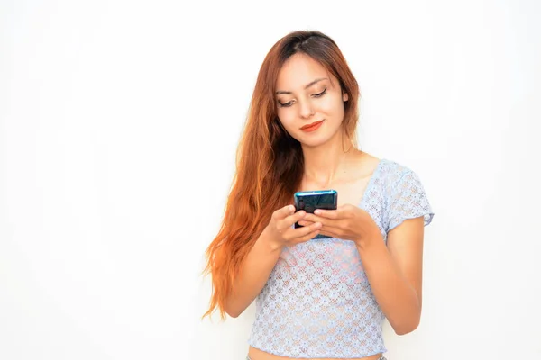 Cep telefonunda yazı yazan bir kız. Akıllı telefondan mesaj atan bir kadın. - Yakın çekim. Akıllı telefon kullanan bir kadın. İletişim cihazı. Kız cep telefonuna mesaj yazıyor.