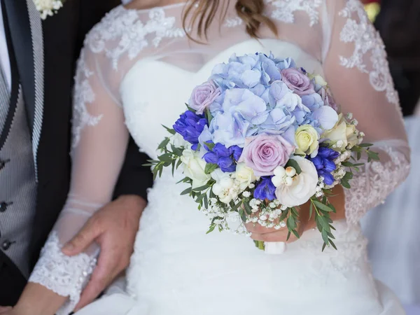 A floral wedding bouquet in bride's hands