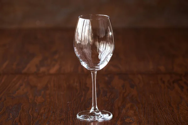 Leeg wijnglas op de donkere houten tafel — Stockfoto