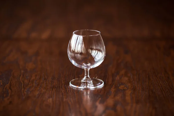 Elegant cognac glas op de donkere houten tafel — Stockfoto